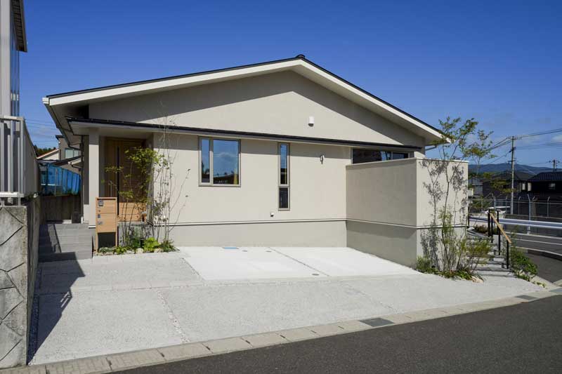 白い外壁と緑が織りなす、自然と調和した外構デザイン