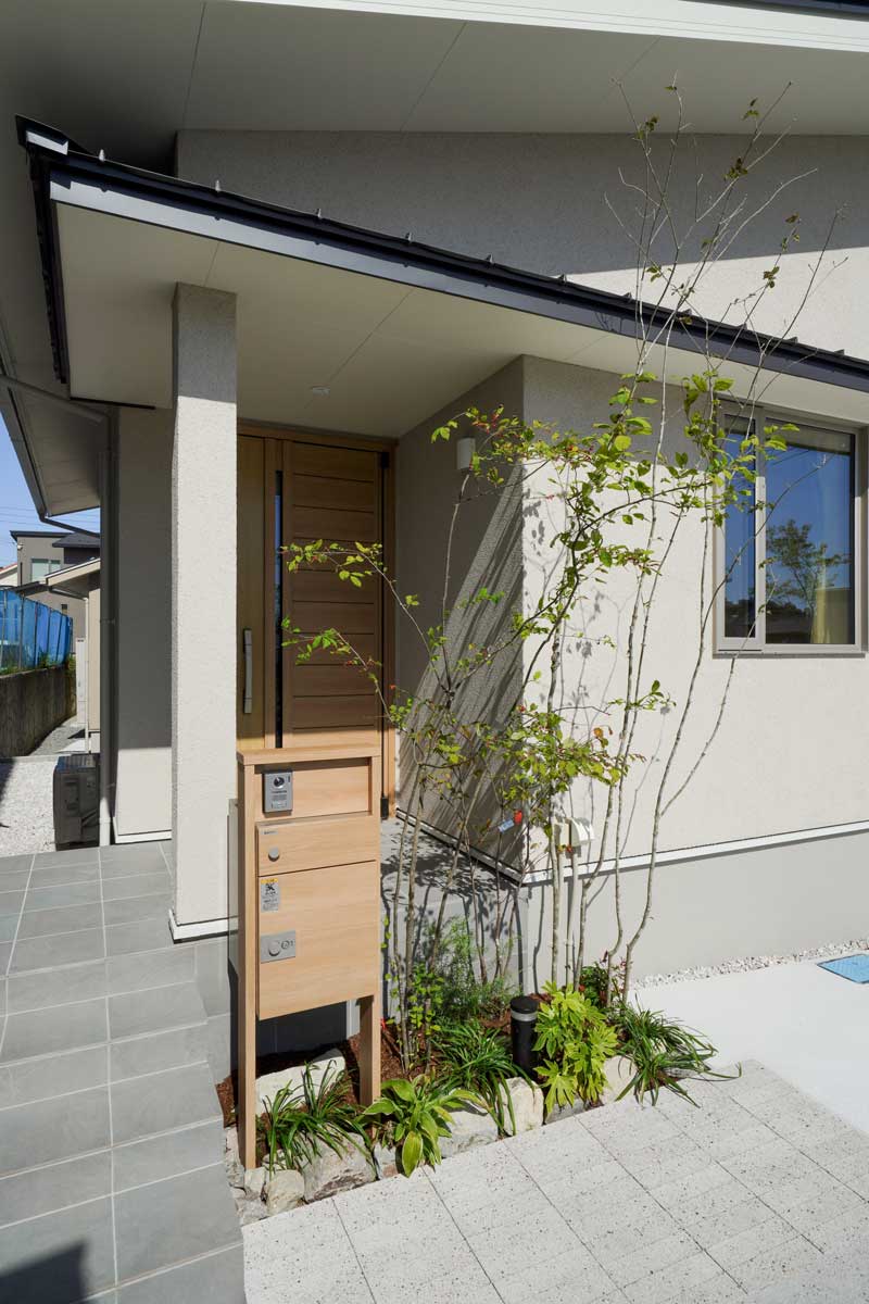 白い外壁と緑が織りなす、自然と調和した外構デザイン