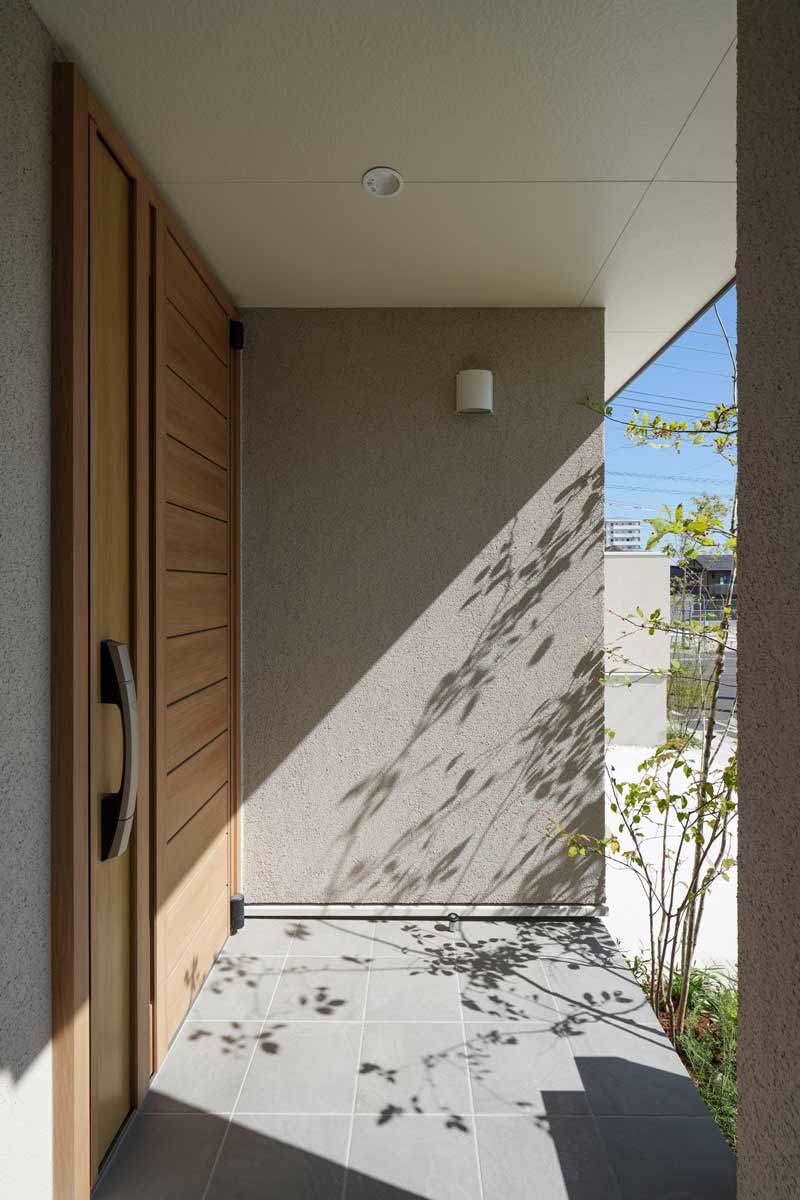 白い外壁と緑が織りなす、自然と調和した外構デザイン