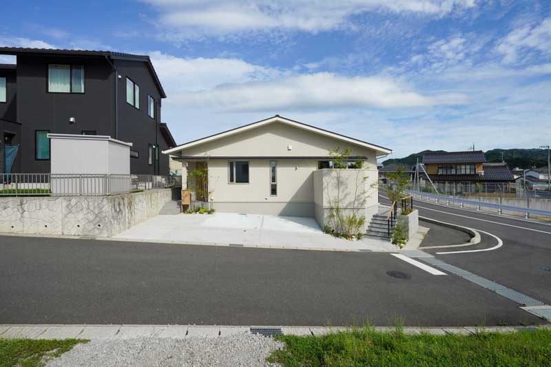 白い外壁と緑が織りなす、自然と調和した外構デザイン